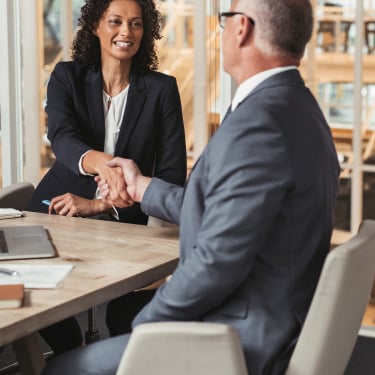 man and woman shaking hands in office