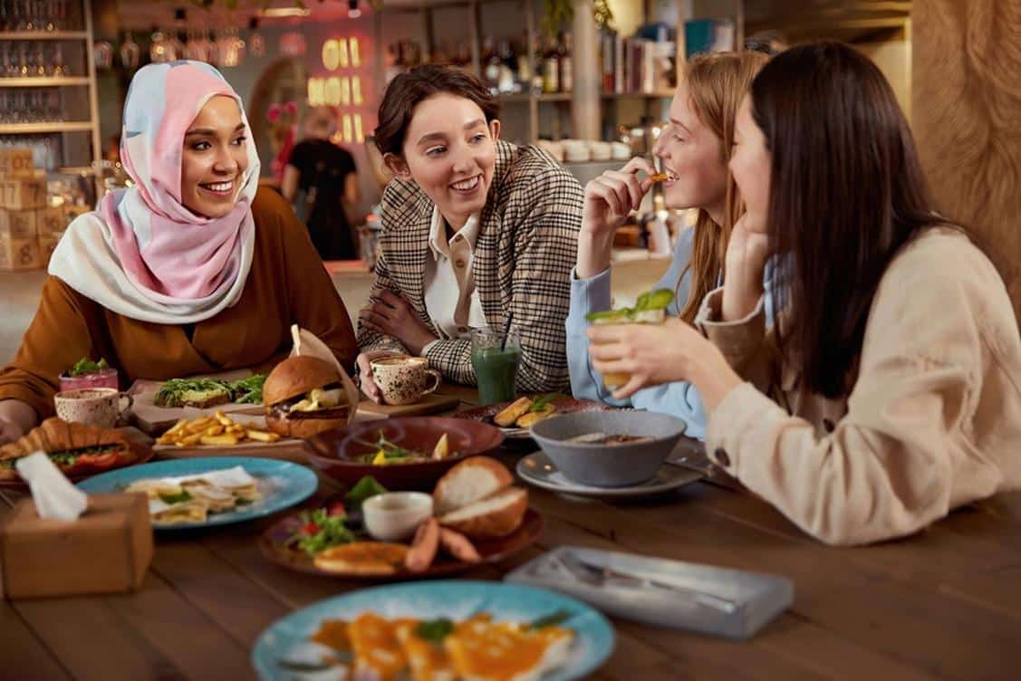A group of four women is having a lunch at a table