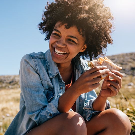 woman eating a sandwich outside