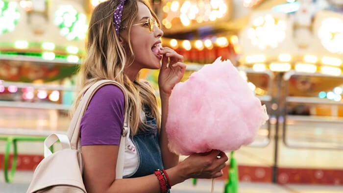 A person eating pink cotton candy