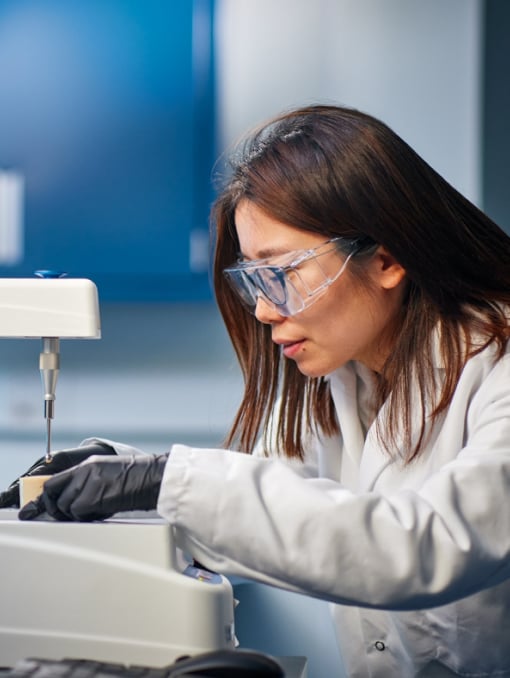 A person wearing safety goggles using equipment