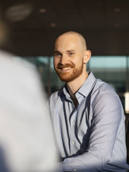 A person smiling inside an office setting