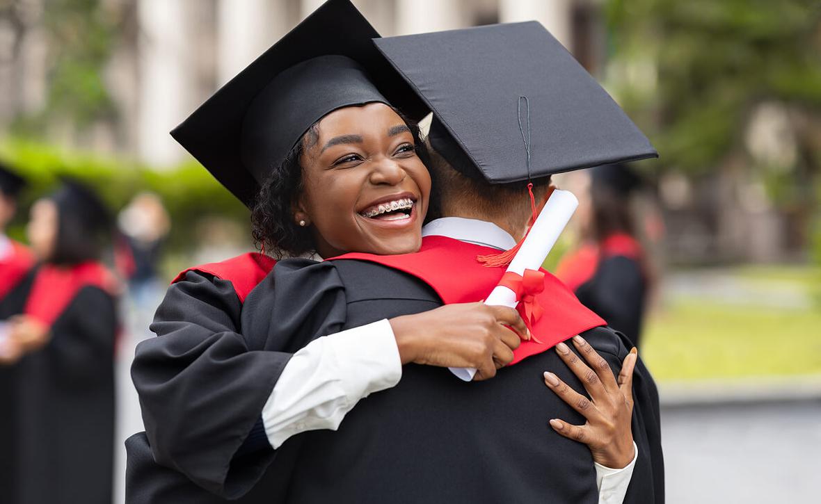 graduate hugging another person