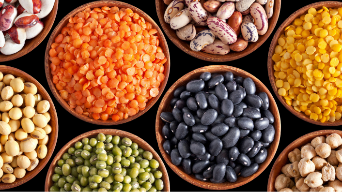 A close-up shot of multiple small bowls containing natural ingredients, such as beans, peas, and more.