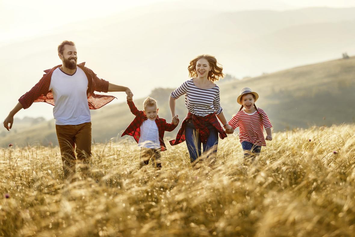 Happy family runing and jumping on sunset AdobeStock 320645375 min