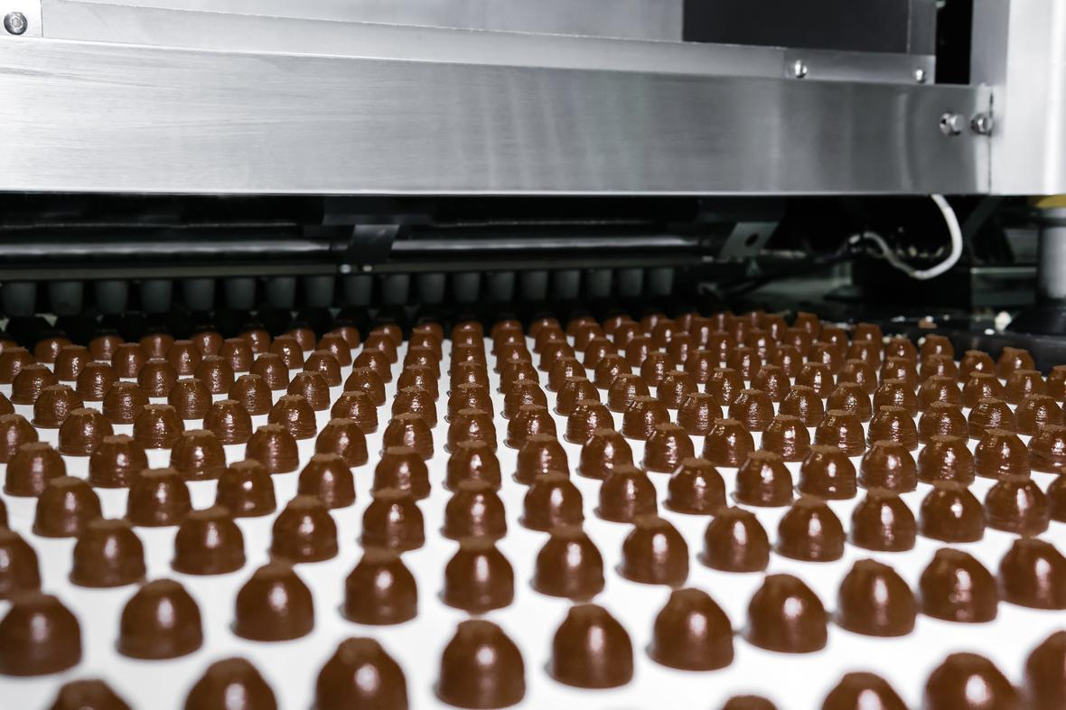 Rows of chocolates coming from a factory oven