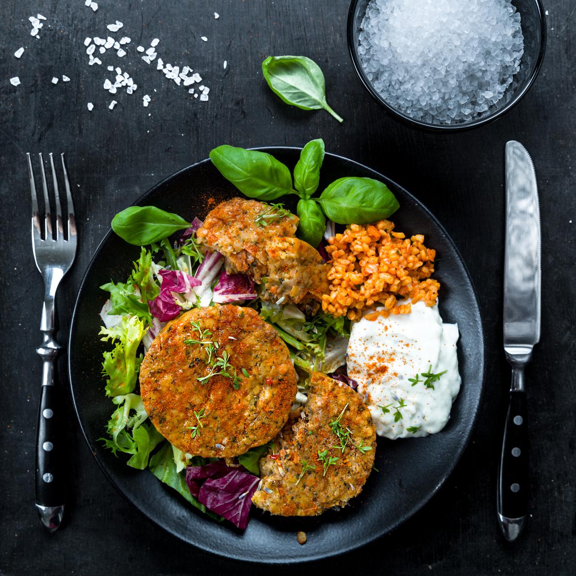Alternative meat patties on a plate with bulgur and lettuce