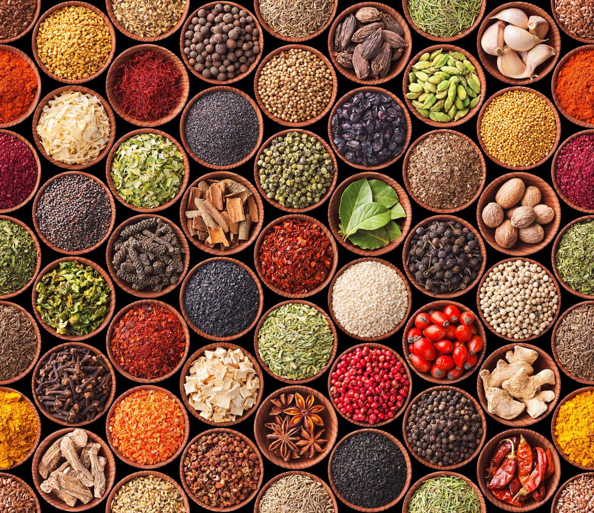 A large variety of colorful spices and herbs in bowls