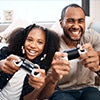 Man and woman laughing and playing video games