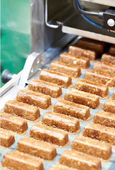 A close-up of a production line of nutritional supplement bars.
