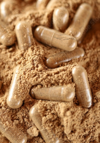 A close-up of protein powder and protein powder capsules.