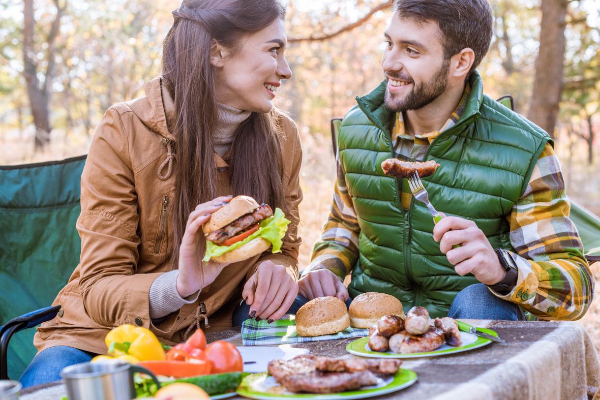 Friends enjoying veggie burgers and sausages outside