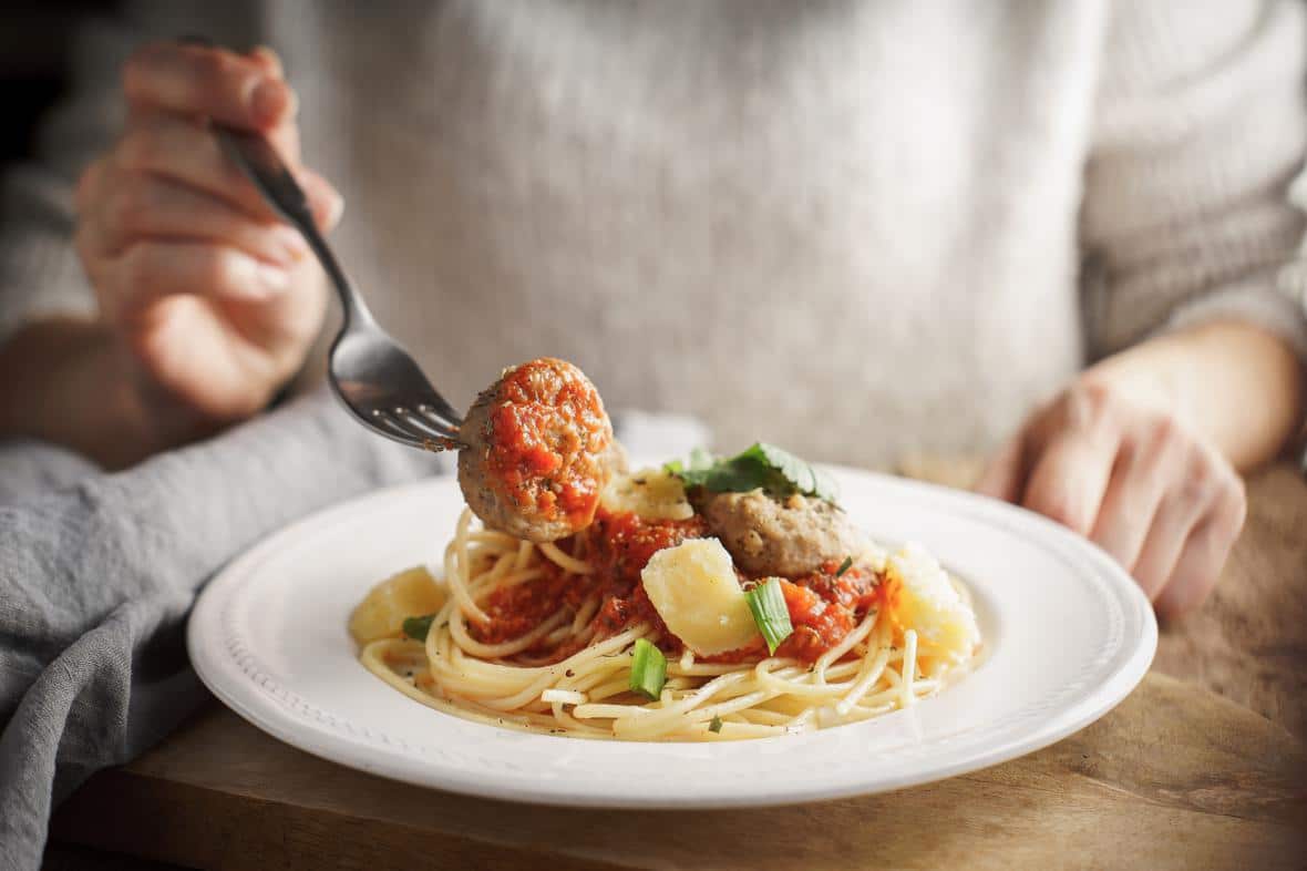 A person enjoying spaghetti with meatballs made of pea protein