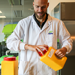 Man with lab coat opening container