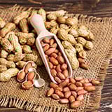 Peanuts in a scoop on a burlap surface