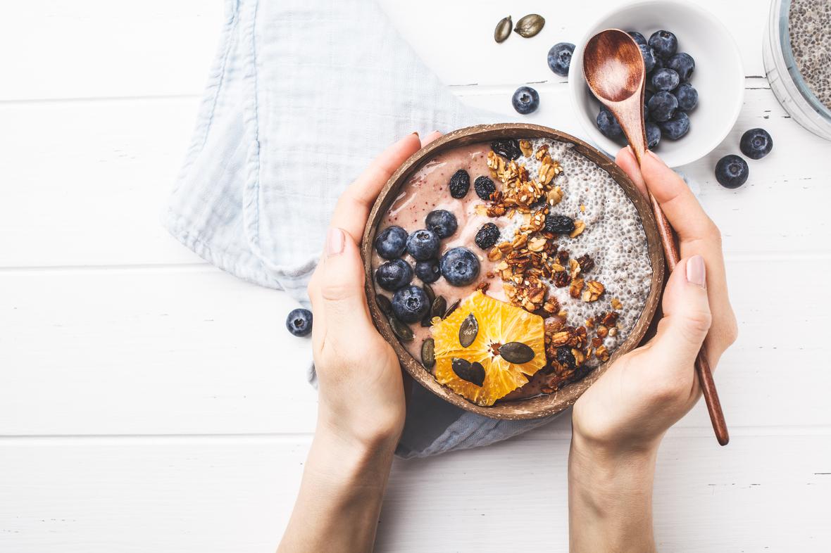 A delicious looking bowl of yogurt with blueberries and multiple types of seeds