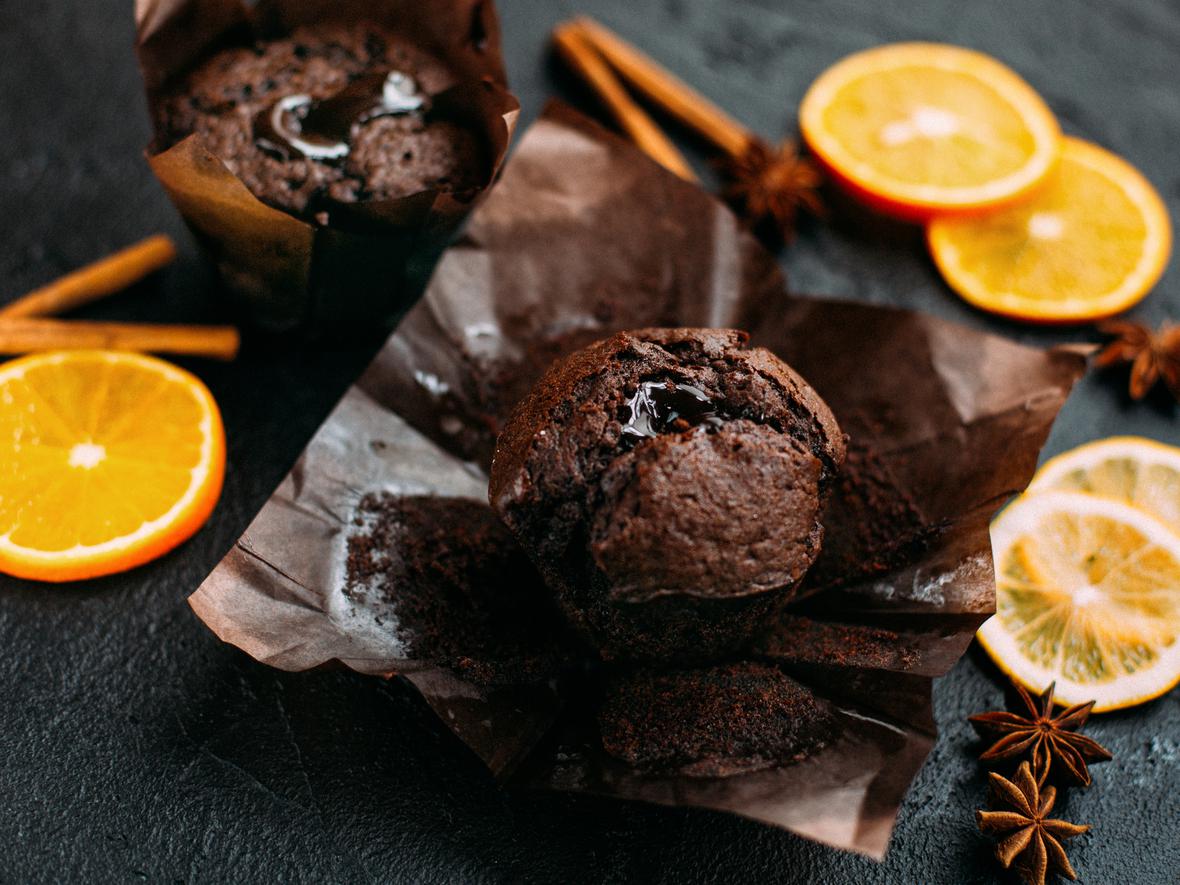 Chocolate cupcakes surrounded by orange slices and cinnamon sticks