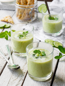 Glasses of a light green smoothie with mint and cucumber garnishes