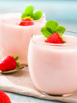 Two glasses of light pink strawberry yogurt