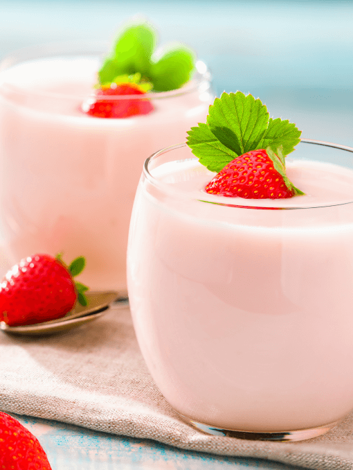 Two glasses of light pink strawberry yogurt