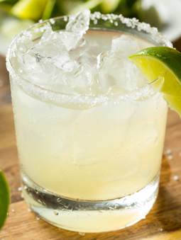 A margarita in a short glass, garnished with a lime
