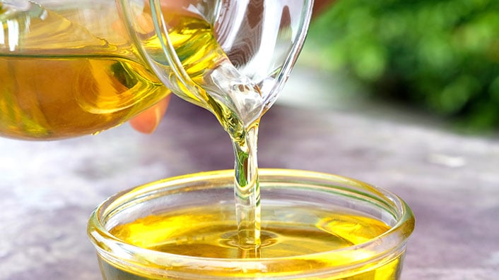 A close-up of oil being poured into a bowl