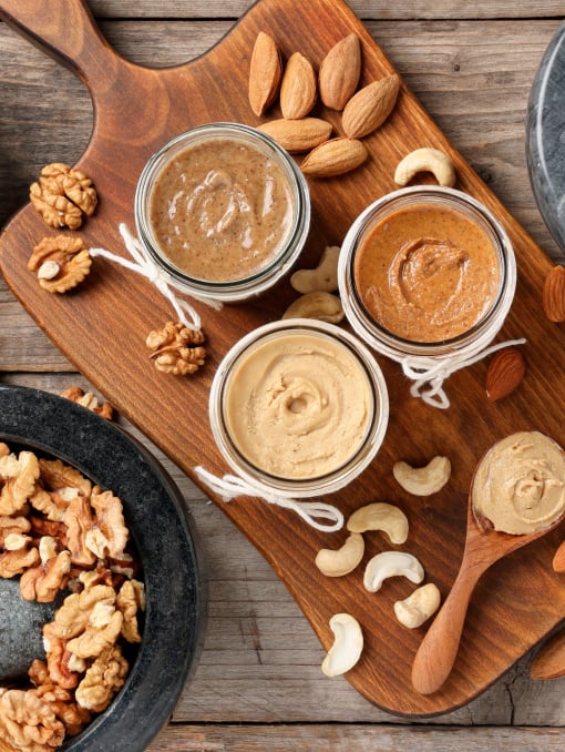 An overhead view of nut spreads on a serving board