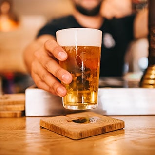 A person holding a glass of beer