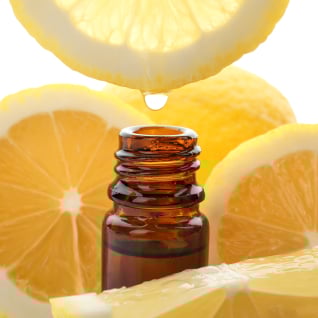 To A bottle of essential oil surrounded by lemon slices