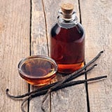 Vanilla extract in a glass bottle and vanilla beans