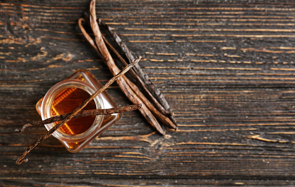 Jar with vanilla extract on a wooden table