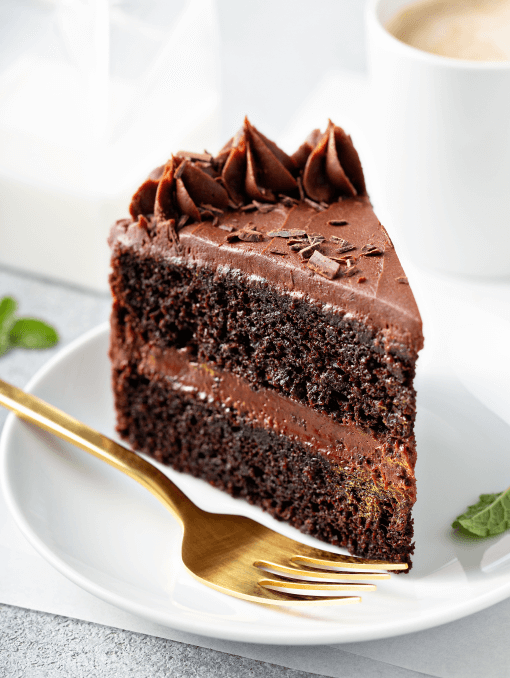 Slice of layered chocolate cake with a gold fork