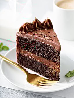 IMAGE ALT TEXT Slice of layered chocolate cake with a gold fork