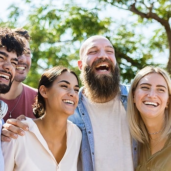 Close-up of for people laughing on a garden, green background