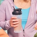 A woman torso with a plastic bottle in hand