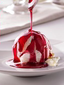 Vanilla ice cream dish with strawberry syrup
