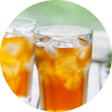  A close-up of glasses of stevia-sweetened iced tea on a picnic bench outside.