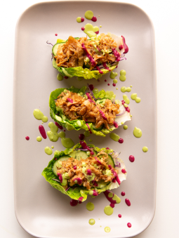 A plate of lettuce cups on a white surface
