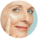 A woman applying cream to her face