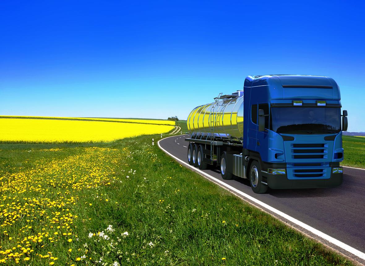 Truck delivering biodiesel driving beside a field