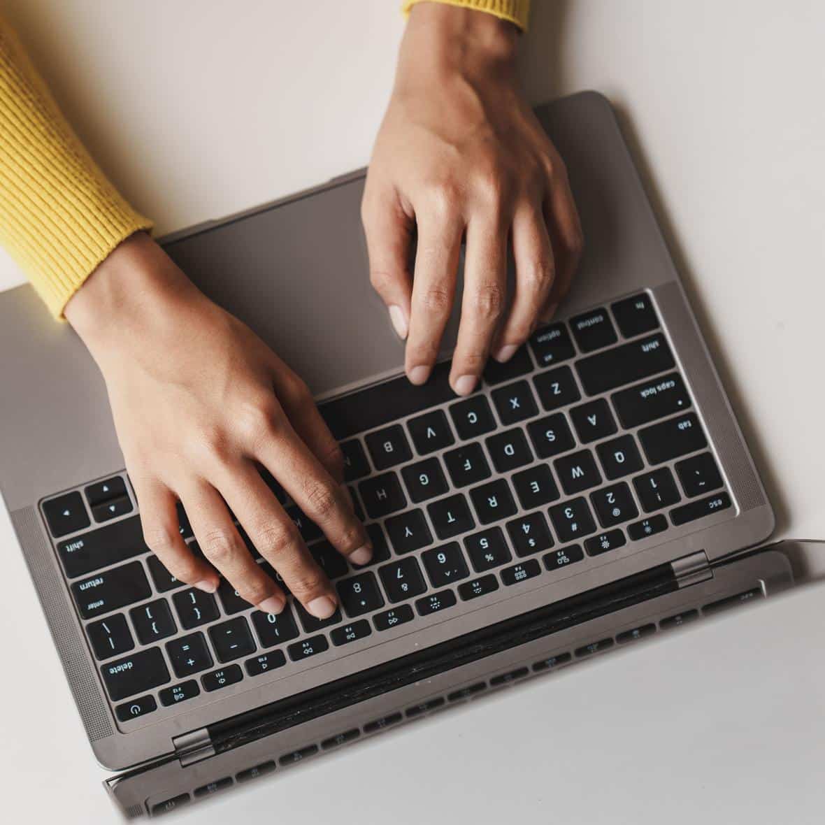 Close-up portrait typing keyboard on laptop computer