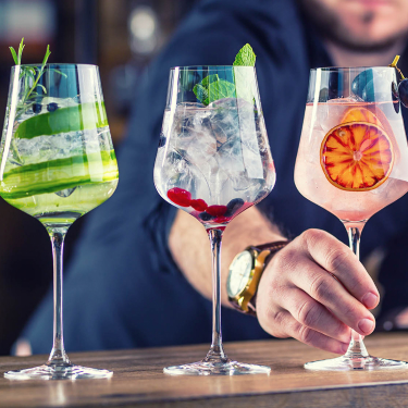 bartender lining up cocktails on bar