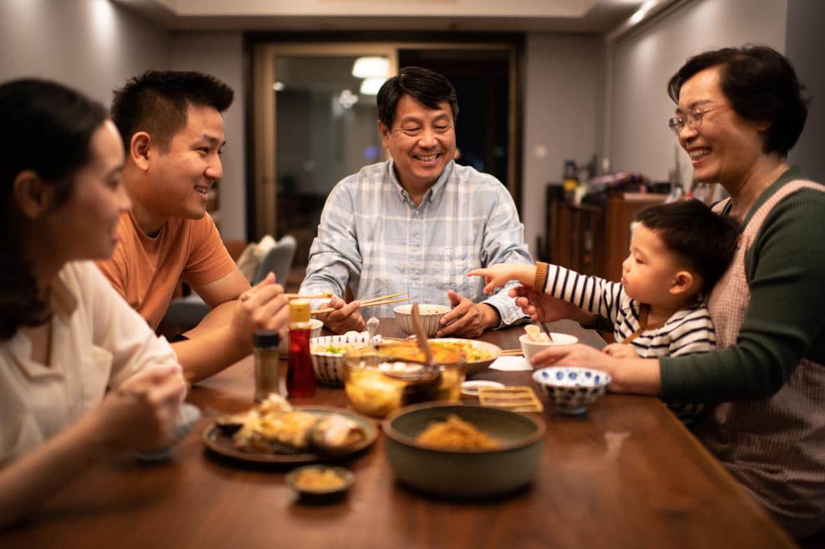 Chinese family having dinner around the dining room table. 