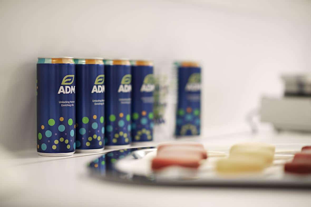 Tray of colorful popsicles on a table, with ADM beverages in the background