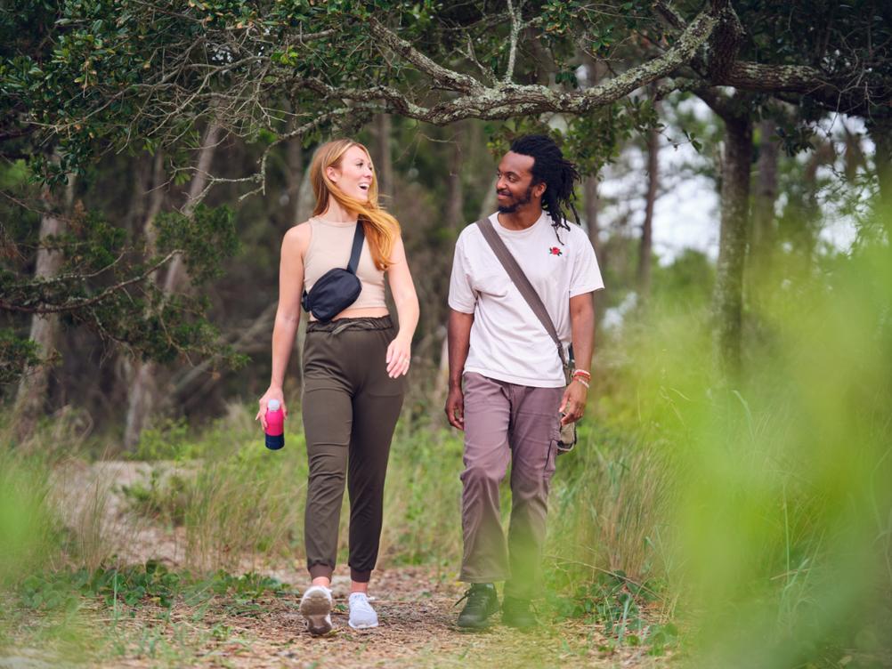 Man and Woman Walking in Nature with Sports Drink