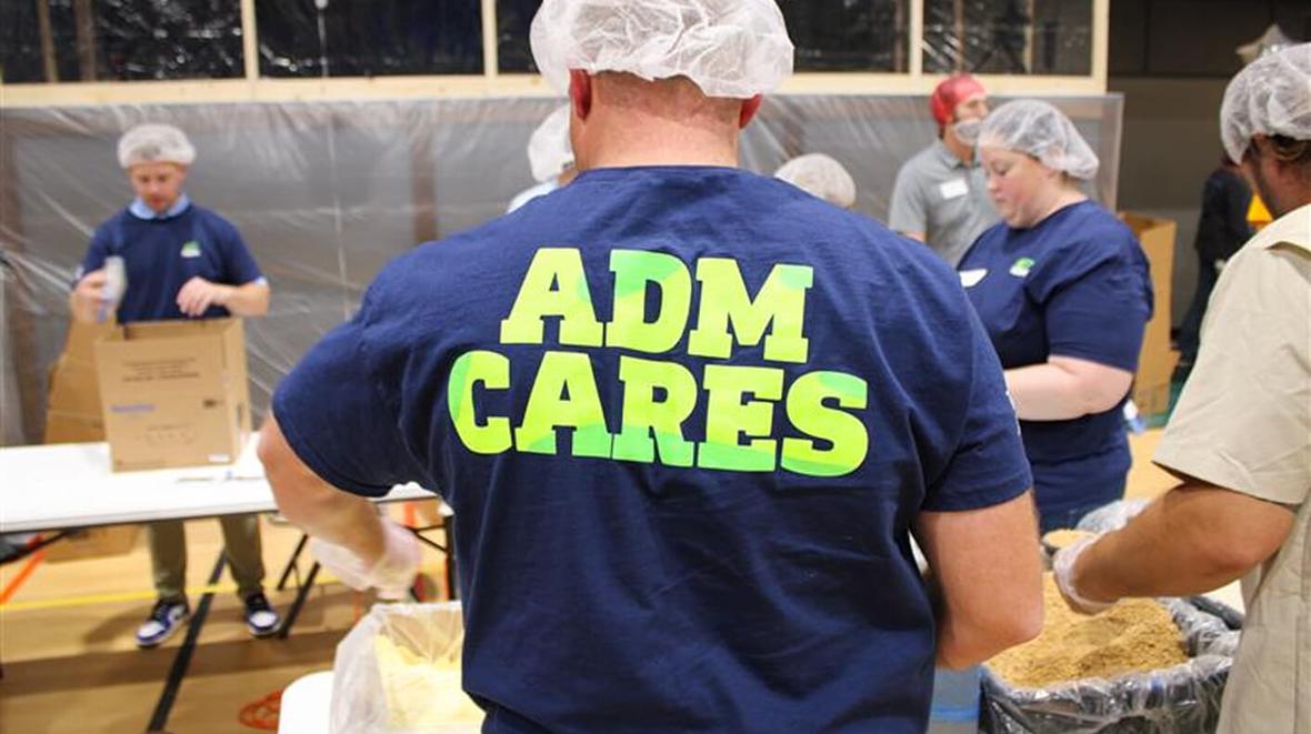 A person wearing a blue shirt with yellow text on it