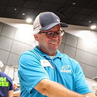 A person wearing a blue shirt and a hat