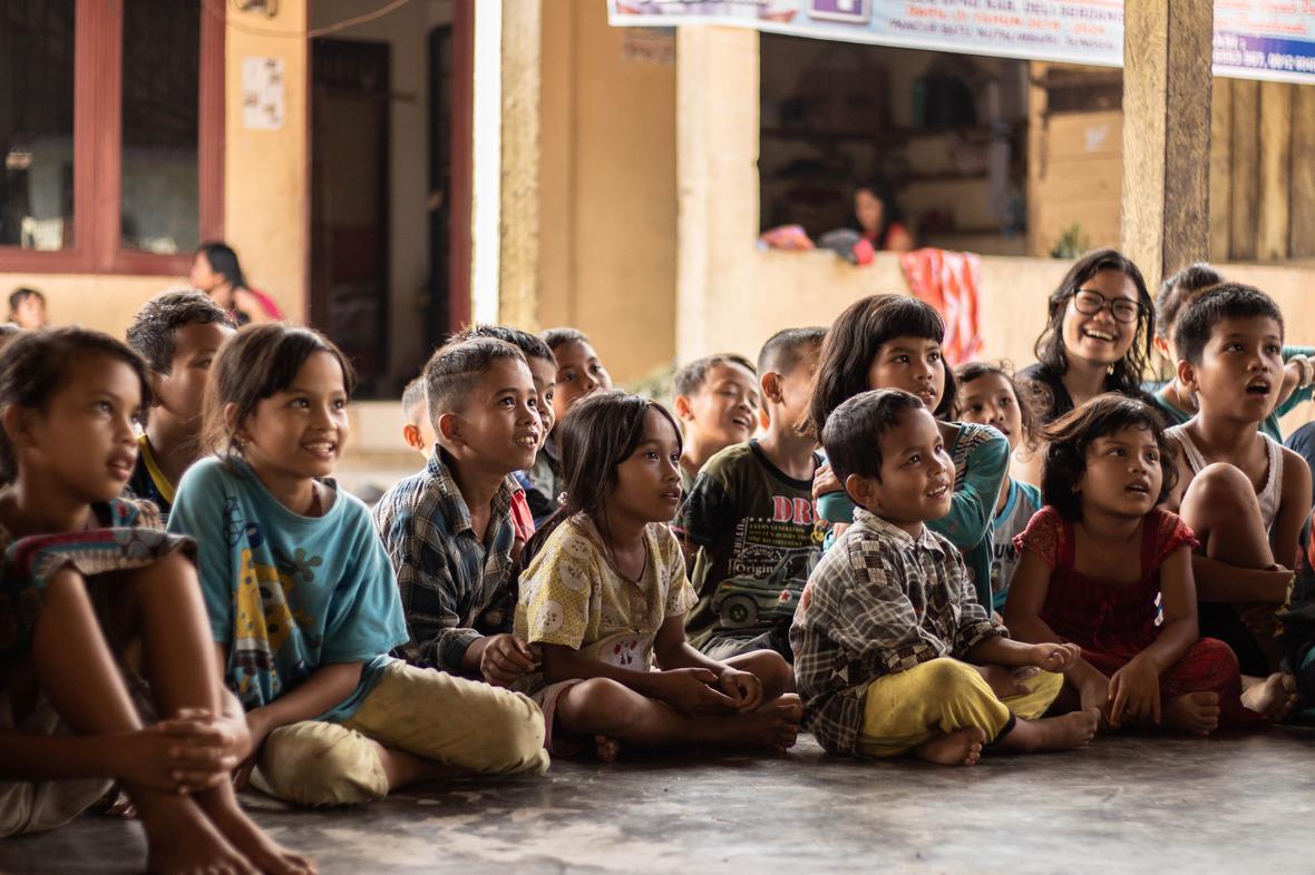 Group of schoolchildren sitting on the ground