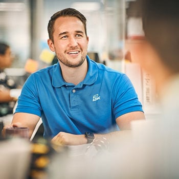 A smiling person in a blue ADM shirt