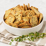 A bowl of whole wheat organic flour crackers with herbs, flaxseed, and spices